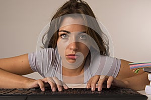 Young attractive student girl or working woman sitting at computer desk in stress looking tired exhausted and boring