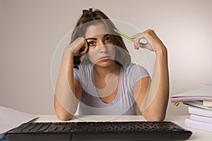 Young attractive student girl or working woman sitting at computer desk in stress looking tired exhausted and boring