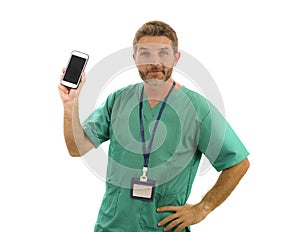 Young attractive and successful medicine doctor or nurse man posing confident  in green medical uniform holding mobile phone