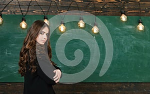 Young attractive teacher pointing at chalkboard. Education first. Student life. Back to school and happy time.