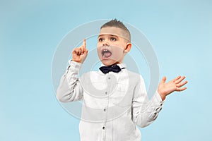 The young attractive teen boy looking suprised isolated on blue