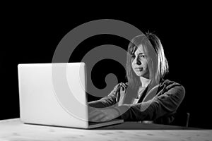 Young attractive teen woman wearing hood on hacking laptop computer cybercrime cyber crime concept