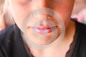 Young attractive teenager girl`s face view with lipstick on lips