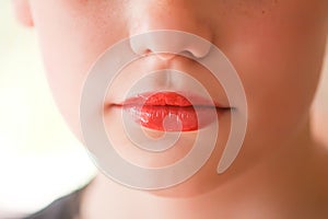 Young attractive teenager girl`s face view with lipstick on lips