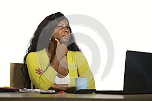 Young attractive and thoughtful black afro American business woman working at office computer desk looking away thinking relaxed i