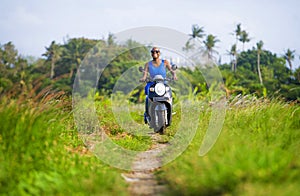 Young attractive tourist afro American black woman riding motorbike happy in beautiful Asia countryside along green rice fields