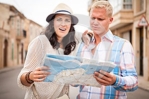 Young attractive tourist couple with city map in summer