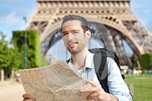 Young attractive tourist reading map in Paris