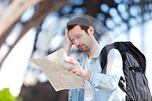Young attractive tourist reading map in Paris