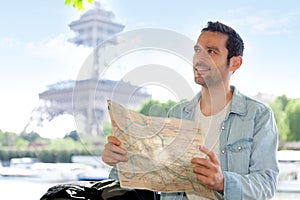 Young attractive tourist reading map in Paris