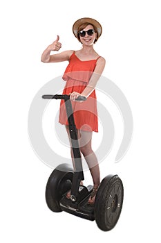 Young attractive tourist woman in chic summer dress smiling happy riding electrical segway