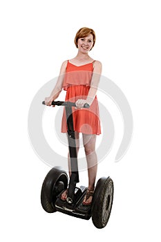 Young attractive tourist woman in chic summer dress smiling happy riding electrical segway