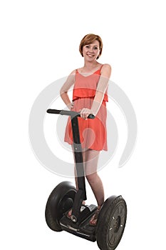 Young attractive tourist woman in chic summer dress smiling happy riding electrical segway