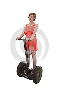 Young attractive tourist woman in chic summer dress smiling happy riding electrical segway