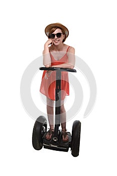 Young attractive tourist woman in chic summer dress smiling happy riding electrical segway