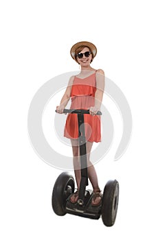 Young attractive tourist woman in chic summer dress smiling happy riding electrical segway