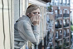 Young attractive unhappy depressed lonely woman looking hopeless ans sad on the balcony at home
