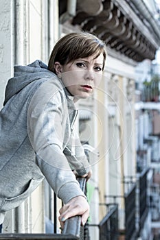 Young attractive unhappy depressed lonely woman looking sad on the balcony at home