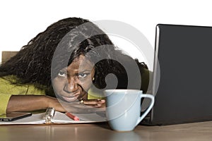 Young attractive unhappy and exhausted black African American woman working lazy on Monday at office computer desk feeling overwhe