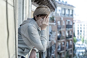 Young attractive unhappy lonely woman with depression looking sad on the balcony at home
