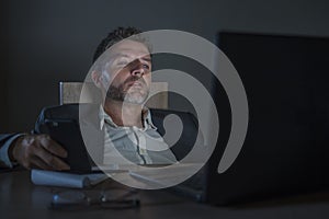 Young attractive wasted and tired entrepreneur man sleeping taking nap late night at office laptop computer desk exhausted in