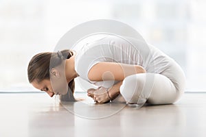 Young attractive woman in baddha konasana pose against floor win photo