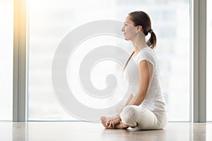 Young attractive woman in baddha konasana pose against floor win photo