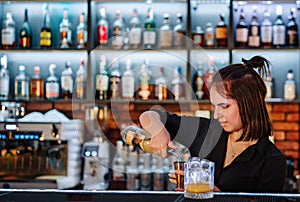 Young attractive woman bartender Making Cocktail in bar