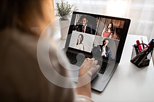 Young attractive woman with black cute dog speak with collegues by computer at home