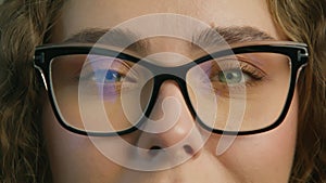 Young attractive woman in black framed eyeglasses posing for closeup slow motion