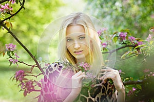 Young attractive woman in blooming spring trees