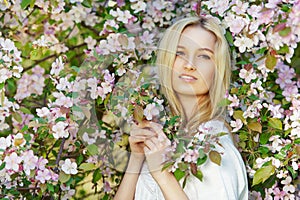 Young attractive woman in blooming spring trees