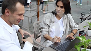 Young attractive woman at business meeting with friends laughing talk sitting in outdoor cafe. slow motion close up