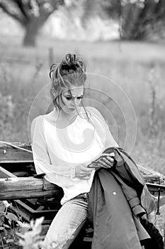 Young attractive woman is busy with her mobile phone doing selfies, writing, reading