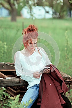 Young attractive woman is busy with her mobile phone doing selfies, writing, reading