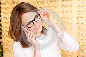 Young attractive woman calling in an optician shop