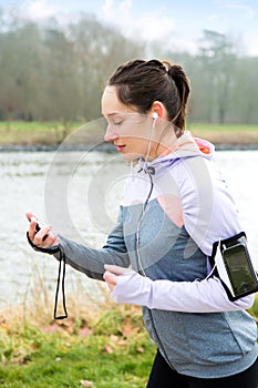 Young attractive woman checking a chronometer durng a running se