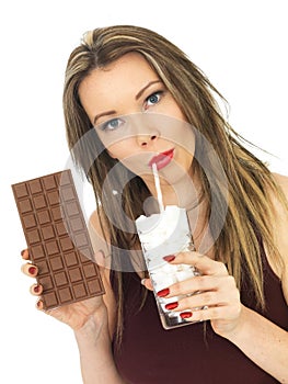 Young Attractive Woman Comparing a Chocolate Bar to a Glass of Sugar