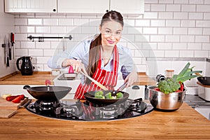 Young attractive woman cooking in kitchen.