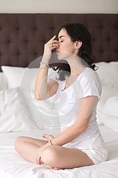 Young attractive woman doing Alternate Nostril Breathing pose on photo