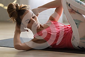 Young attractive woman doing crisscross crunches fitness exercise