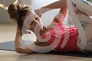 Young attractive woman doing crisscross crunches fitness exercise photo