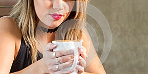 Young attractive woman drinking a delicious hot beverage