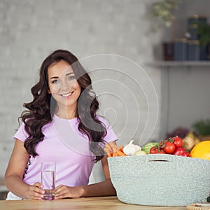 Young attractive woman drinking water on kitchen.