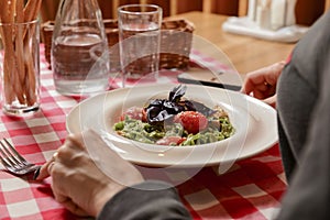 Young attractive woman eating meal set of spaghetti, green spinach pasta. Still life, eating out in restaurant