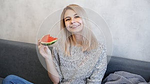 Young attractive woman eating watermelon. Woman looking at camera and smiling