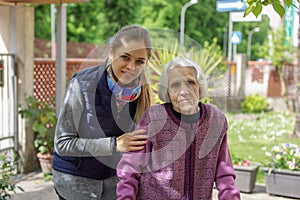 Young attractive woman embracing old grandmother outdoor. Female - generations - love