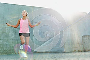 Young attractive woman exercising by jumping on rope