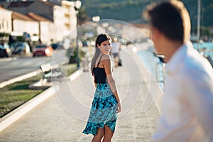 Young attractive woman flirting with a man on the street.Flirty smiling woman looking back on a handsome man.Female attraction