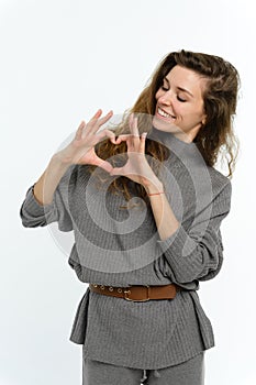 A young attractive woman folded her palms in the shape of a heart